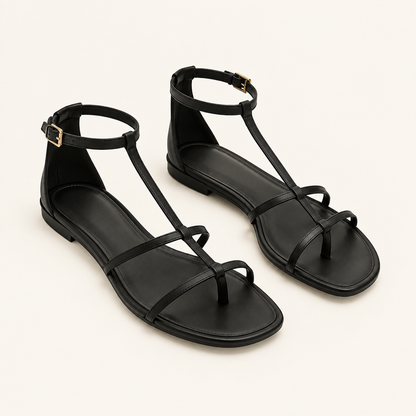 Illustrative pair of black strappy flat sandals on a light beige background.